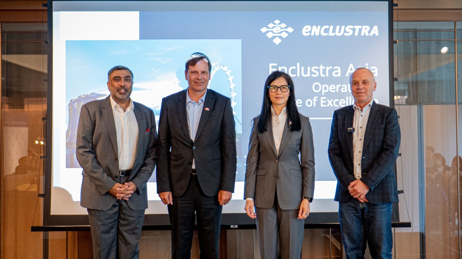 Four attendees on stage in front of the Enclustra Asia launch presentation