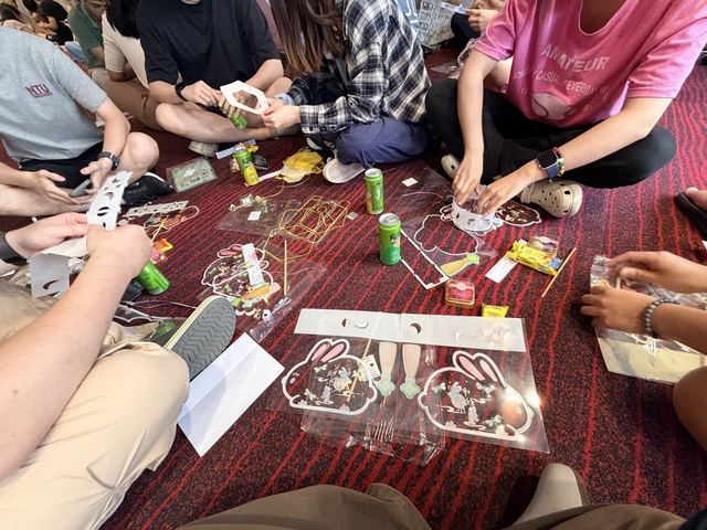 People making paper rabbit lanterns together, with drinks beside them