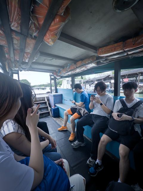 Team members seated inside a bumboat during the crossing to Pulau Ubin