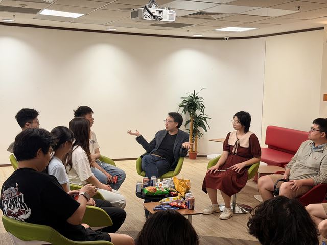 Visiting students seated in a discussion circle with refreshments on the table