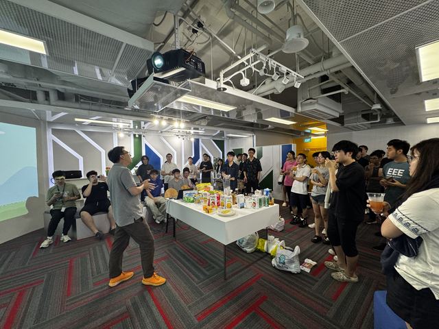 People chatting at a campus welcome gathering, with food on a long table